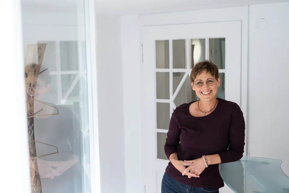 Stefanie Wöhrle lächelnd im hellen Empfang ihrer Praxis in Asperg